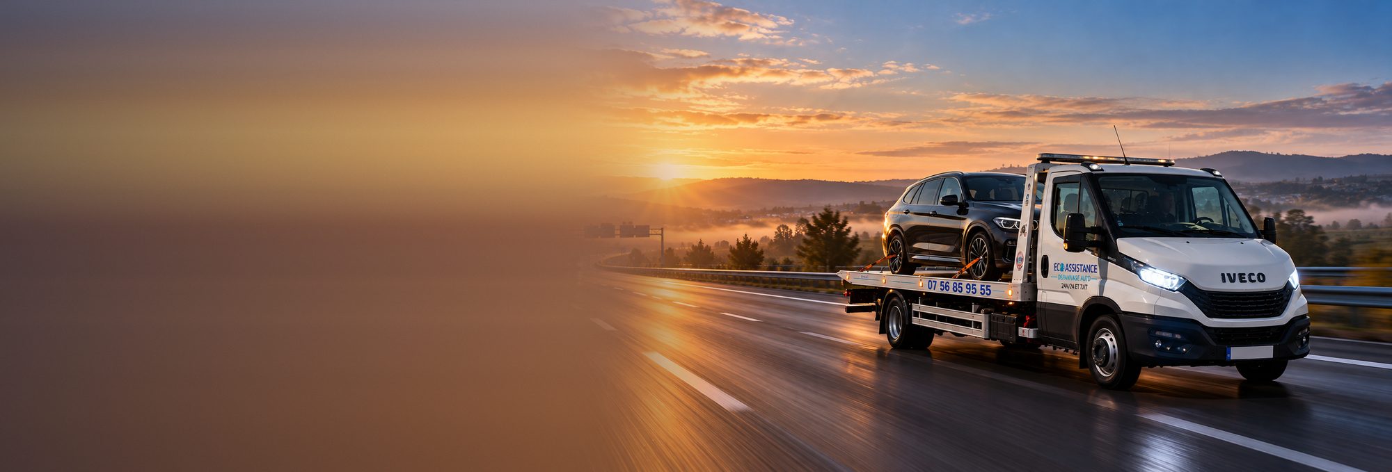 Dépanneuse plateau Iveco Daily ECO ASSISTANCE transportant un SUV sur l'autoroute au lever du soleil, transport de véhicule longue distance